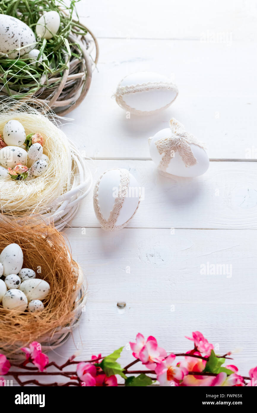 Beautiful Easter background with flowers and nest with eggs on white ...