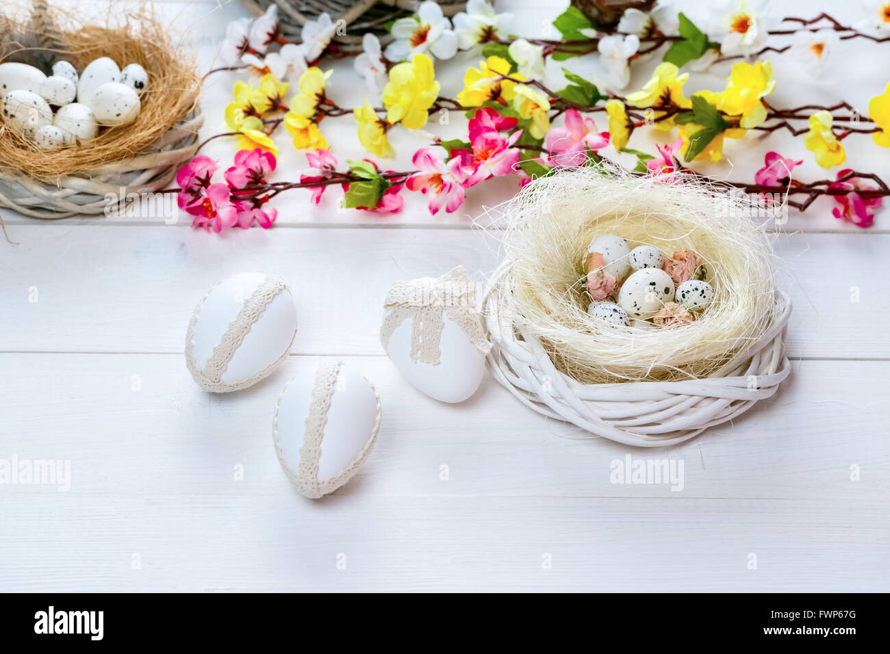 Beautiful Easter background with flowers and nest with eggs on white ...