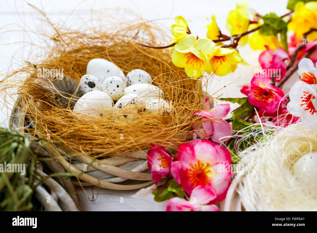 Beautiful Easter background with flowers and nest with eggs on white ...