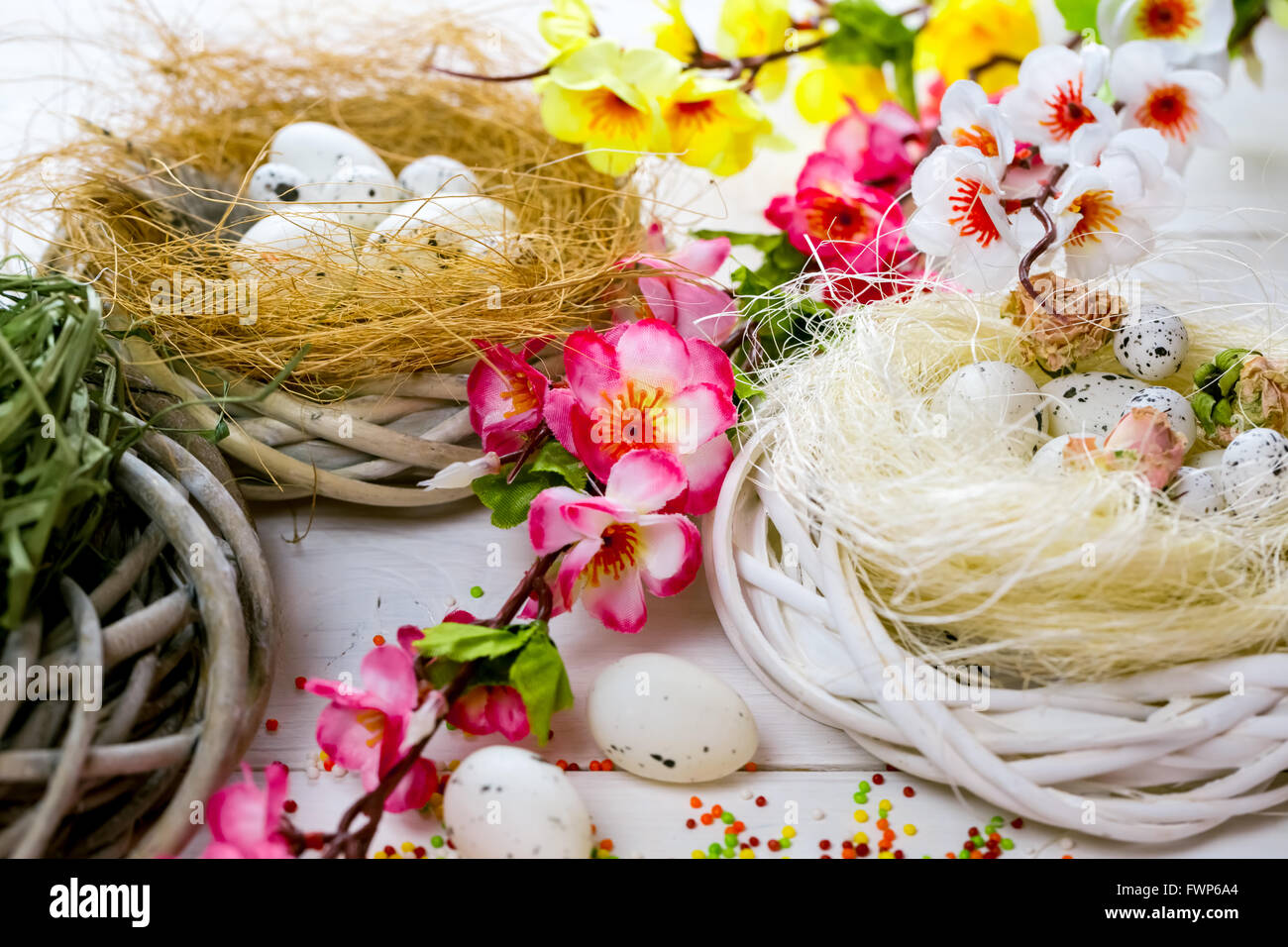 Beautiful Easter background with flowers and nest with eggs on white ...