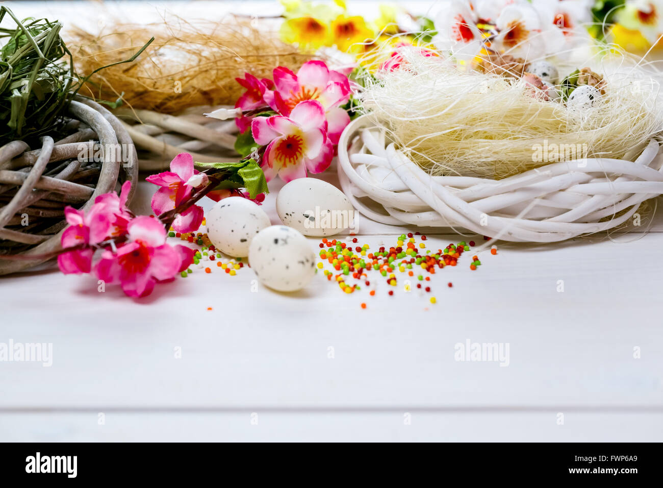 Beautiful Easter background with flowers and nest with eggs on white ...