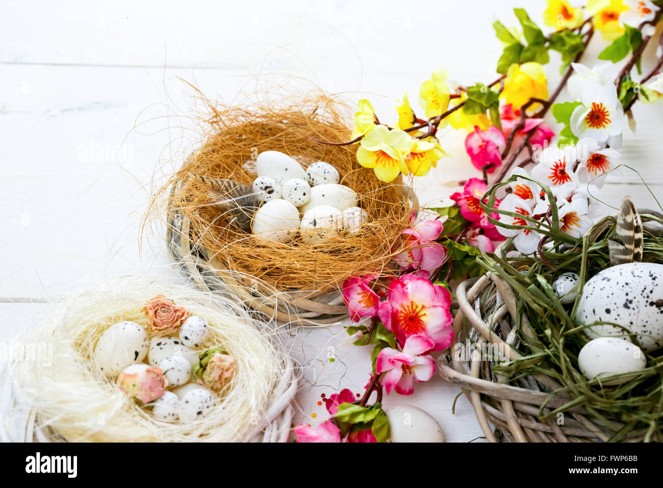 Beautiful Easter background with flowers and nest with eggs on white ...