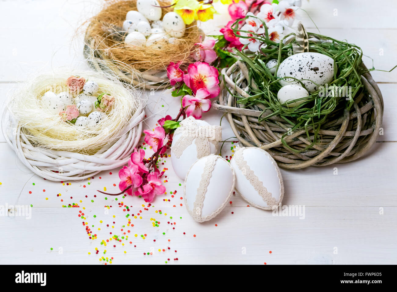 Beautiful Easter background with flowers and nest with eggs on white ...
