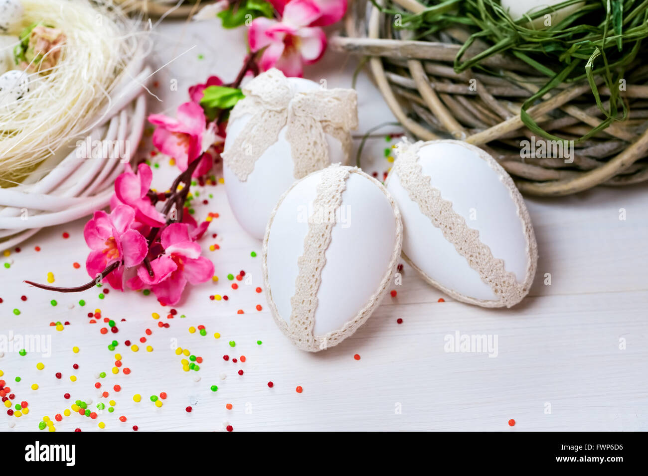 Beautiful Easter background with flowers and nest with eggs on white ...
