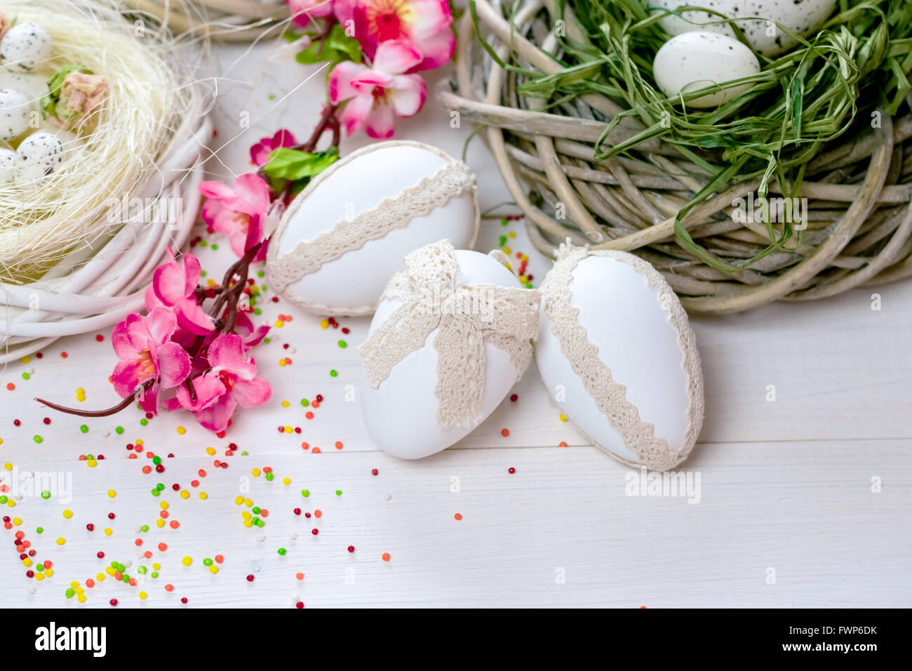 Beautiful Easter background with flowers and nest with eggs on white ...
