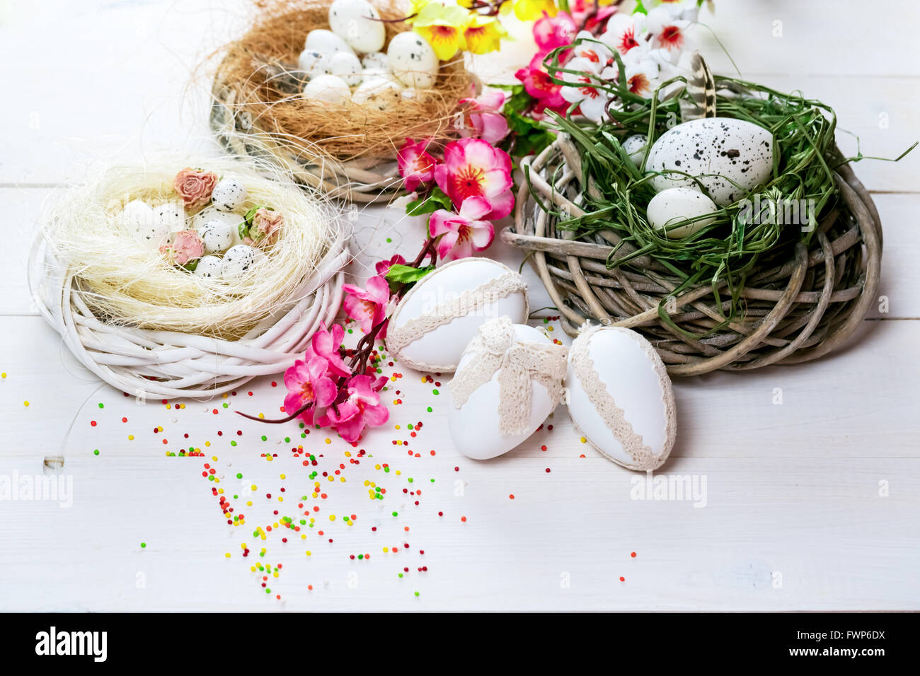 Beautiful Easter background with flowers and nest with eggs on white ...