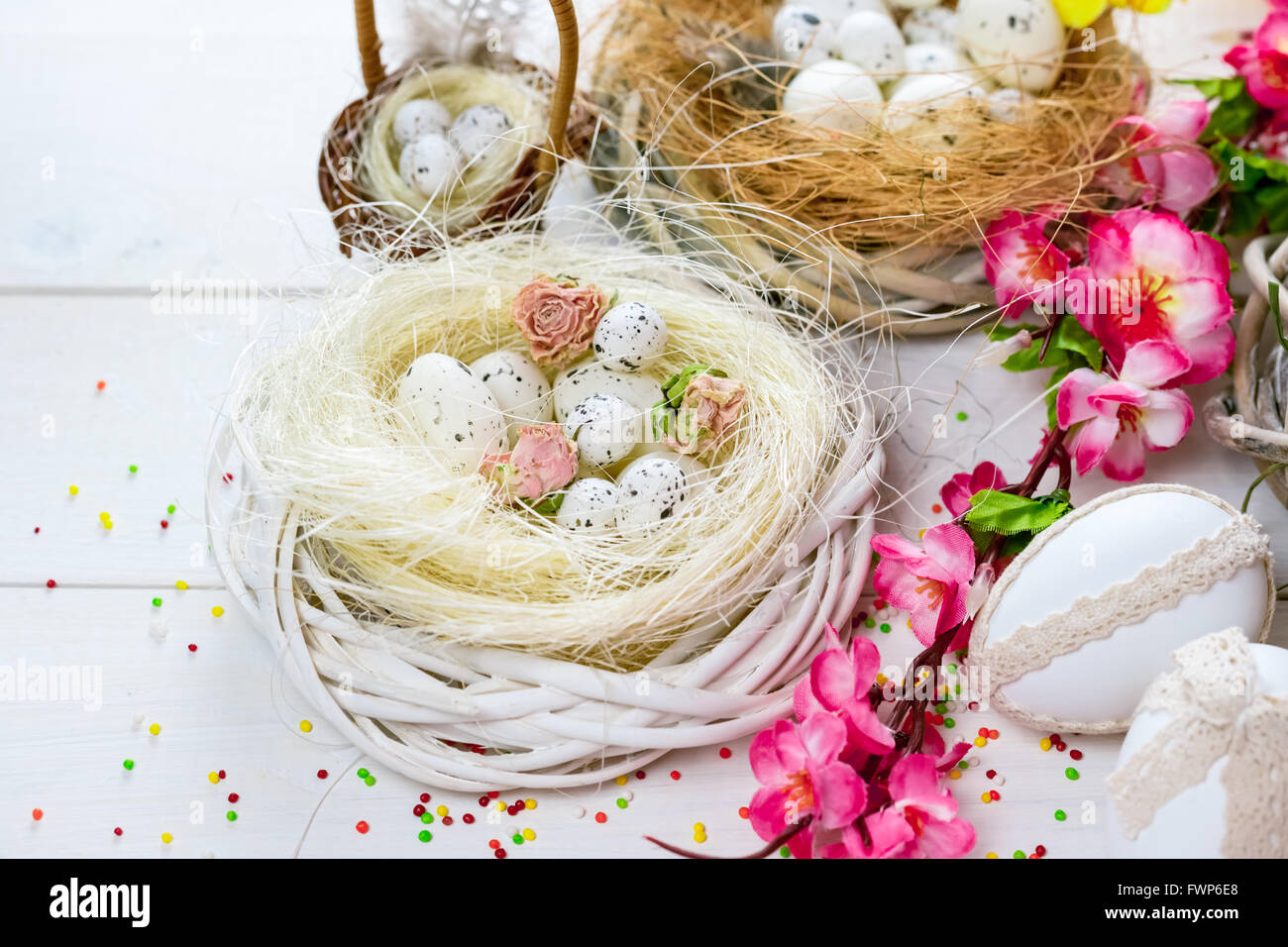 Beautiful Easter background with flowers and nest with eggs on white ...
