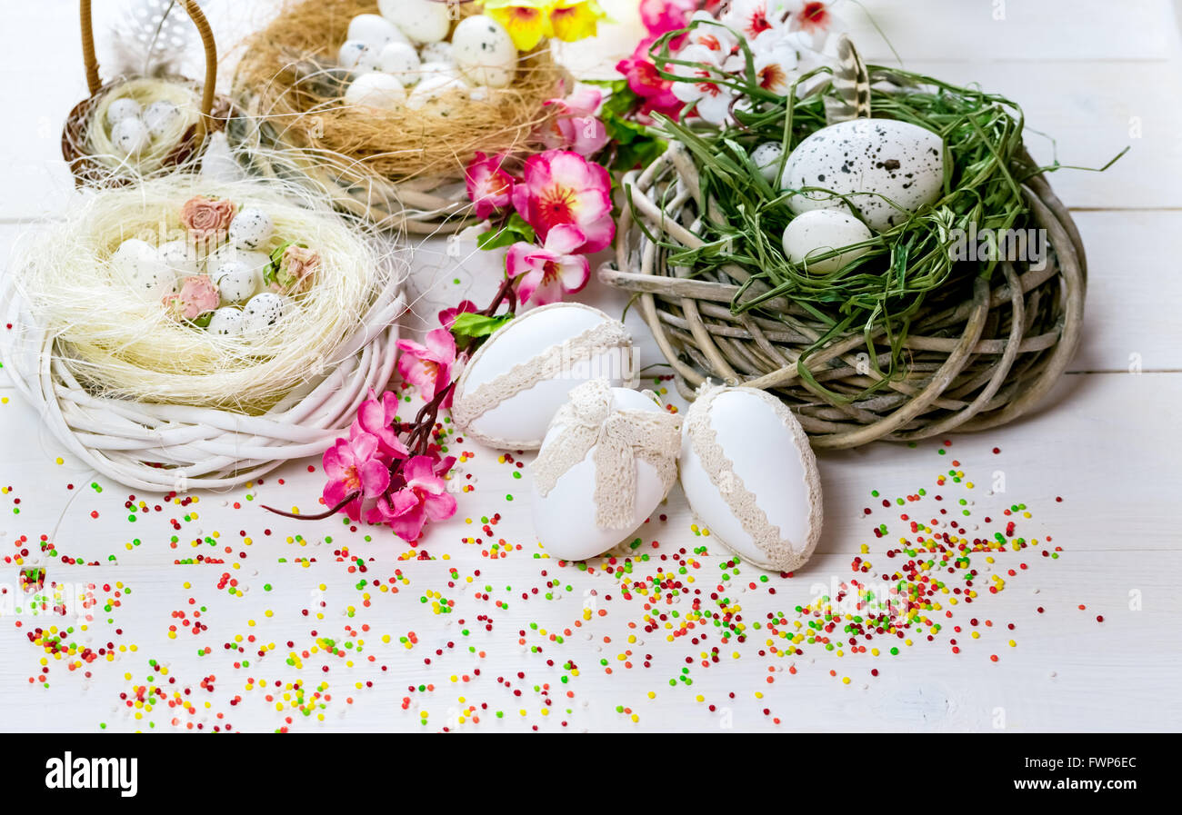 Beautiful Easter background with flowers and nest with eggs on white ...