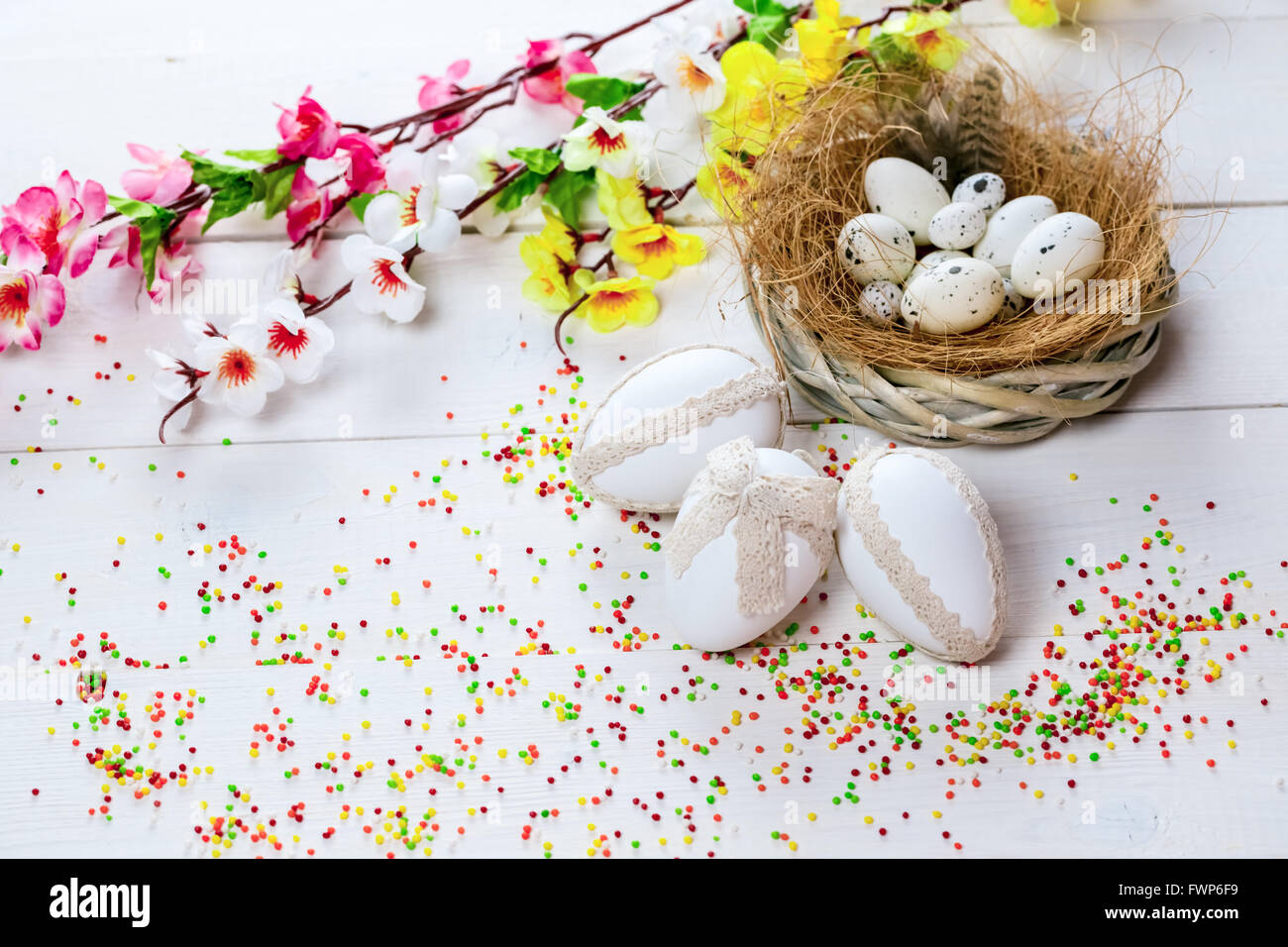 Beautiful Easter background with flowers and nest with eggs on white ...