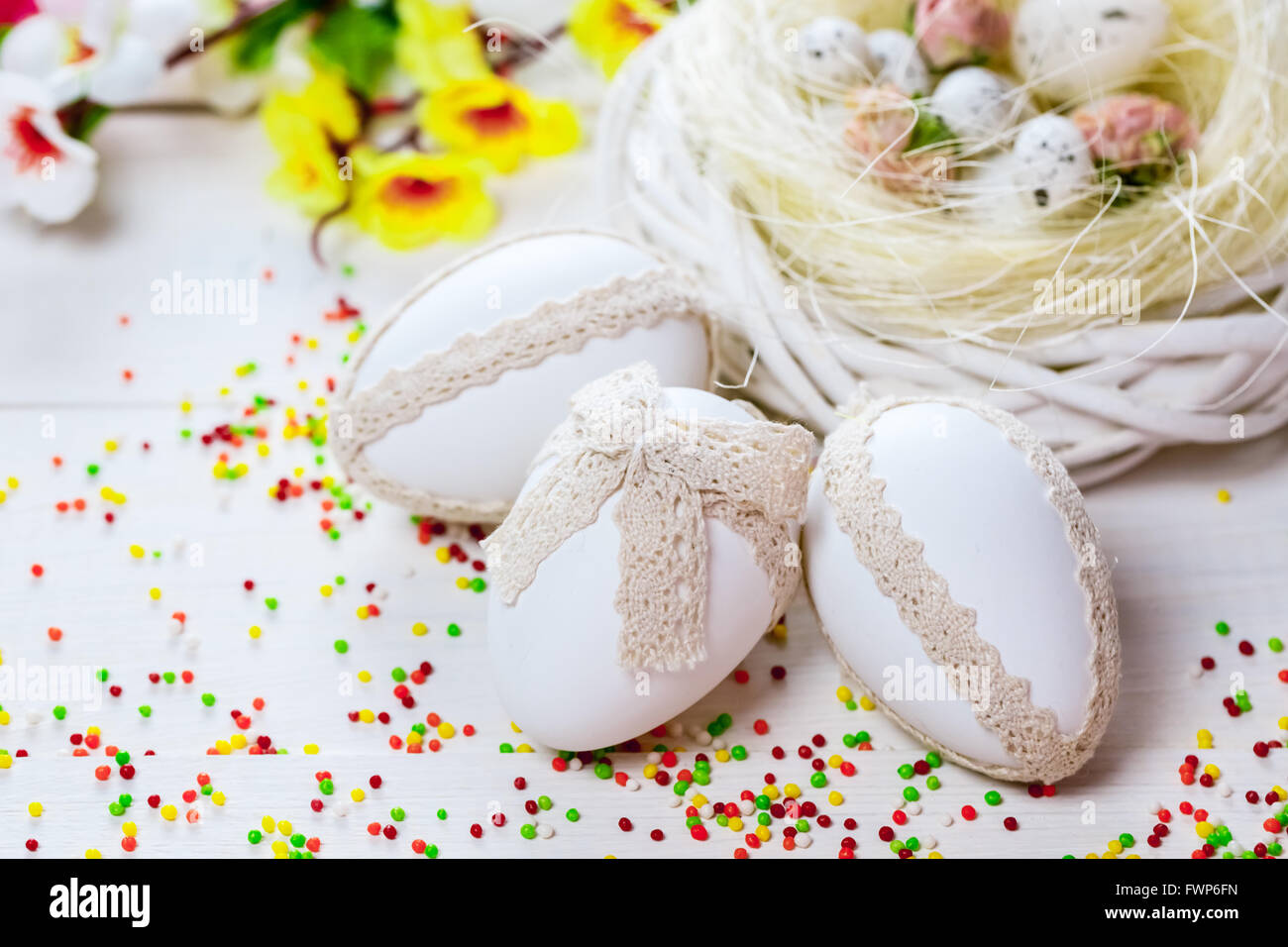 Beautiful Easter background with flowers and nest with eggs on white ...