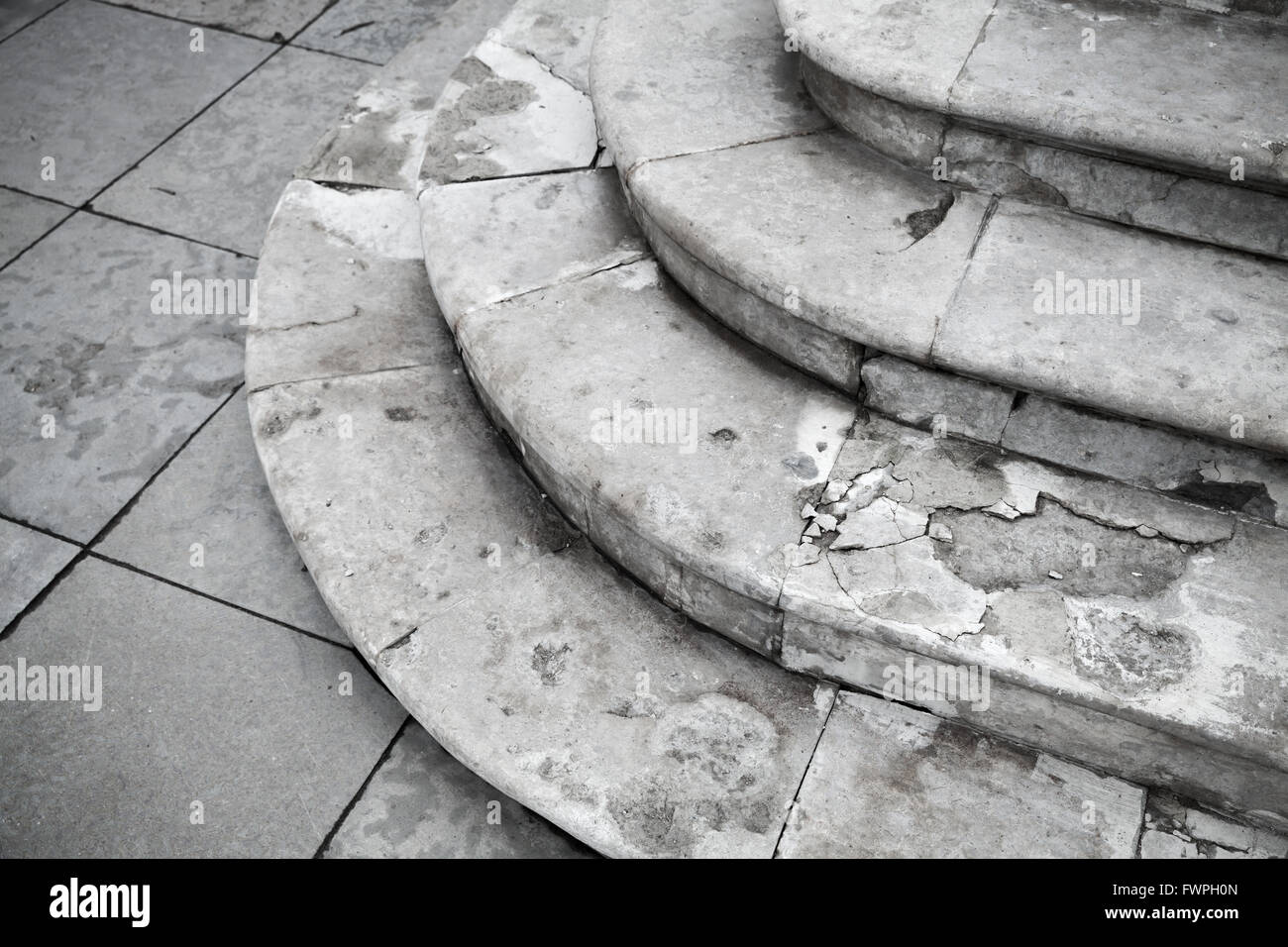 Old grungy white ancient stone stairway with round stairs Stock Photo