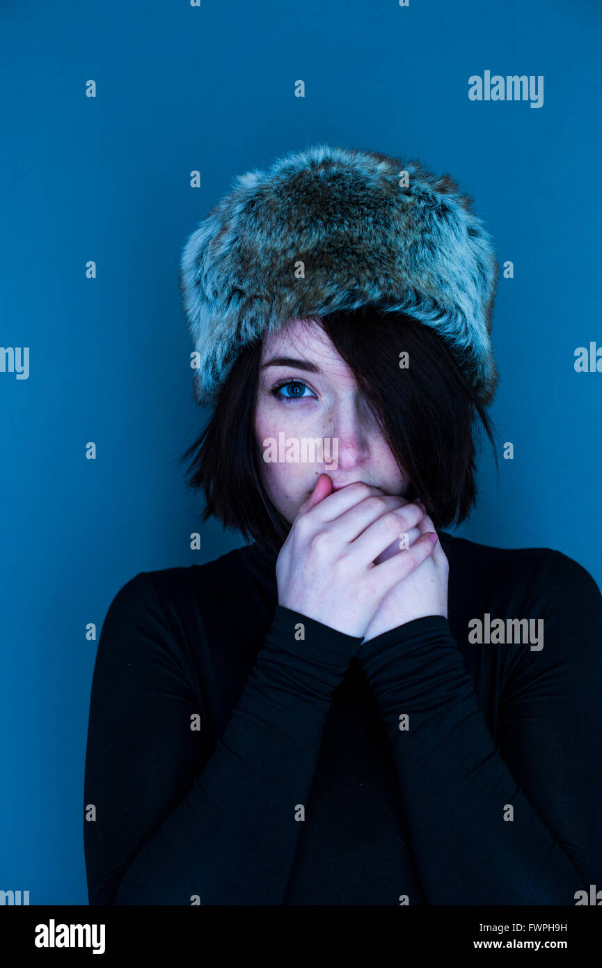 Cold fingers A young person, woman girl, late teens early twenties, slim, brown hair, looking