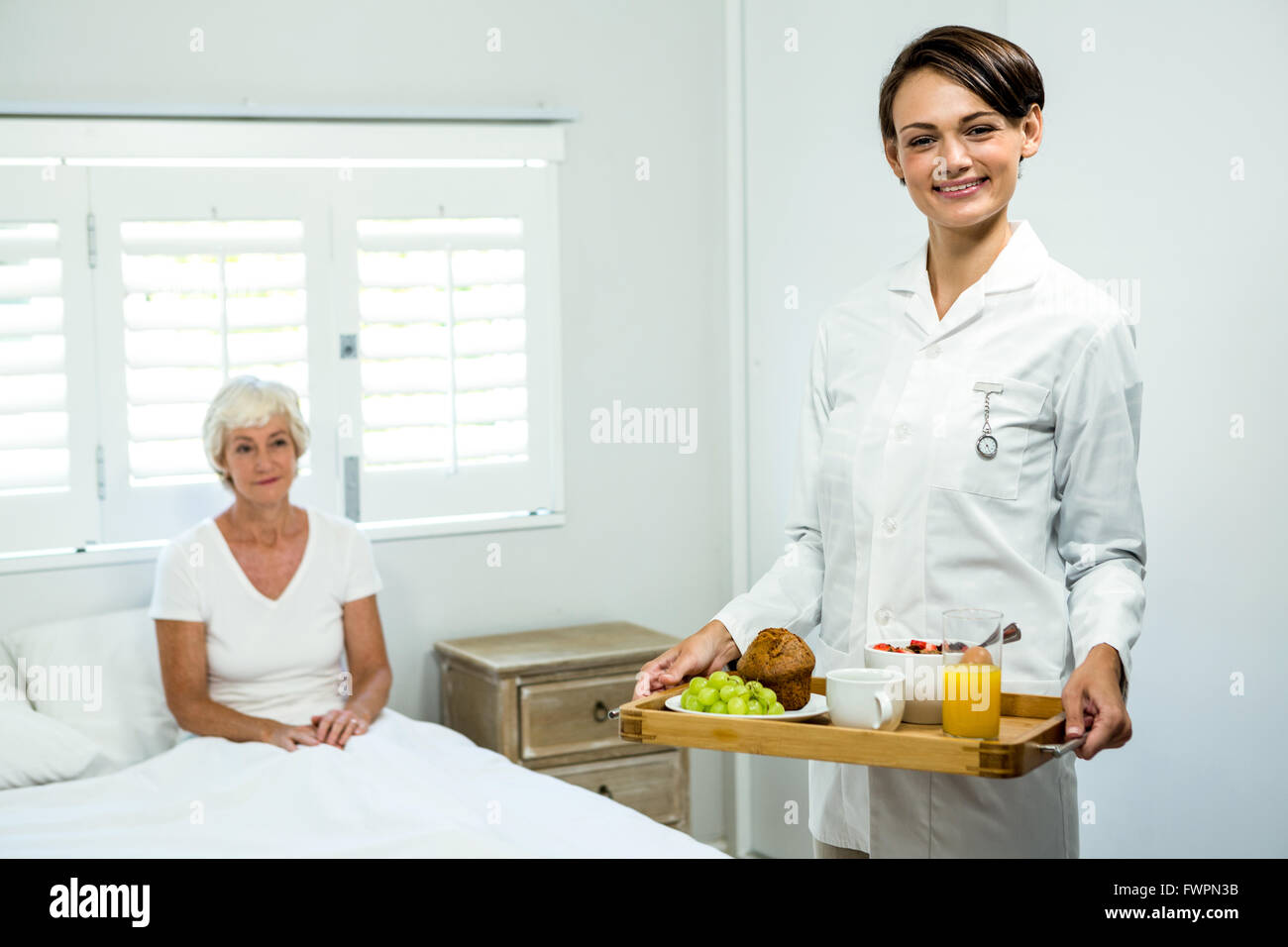 Portrait of smiling caregiver holding breakfast tray Stock Photo - Alamy