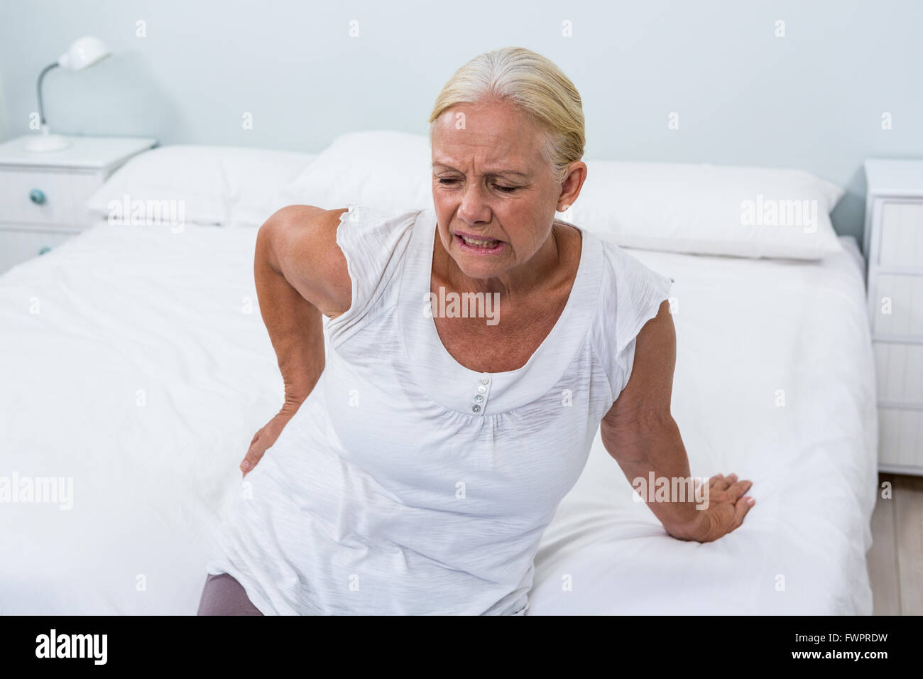 Senior woman suffering from back pain at home Stock Photo - Alamy