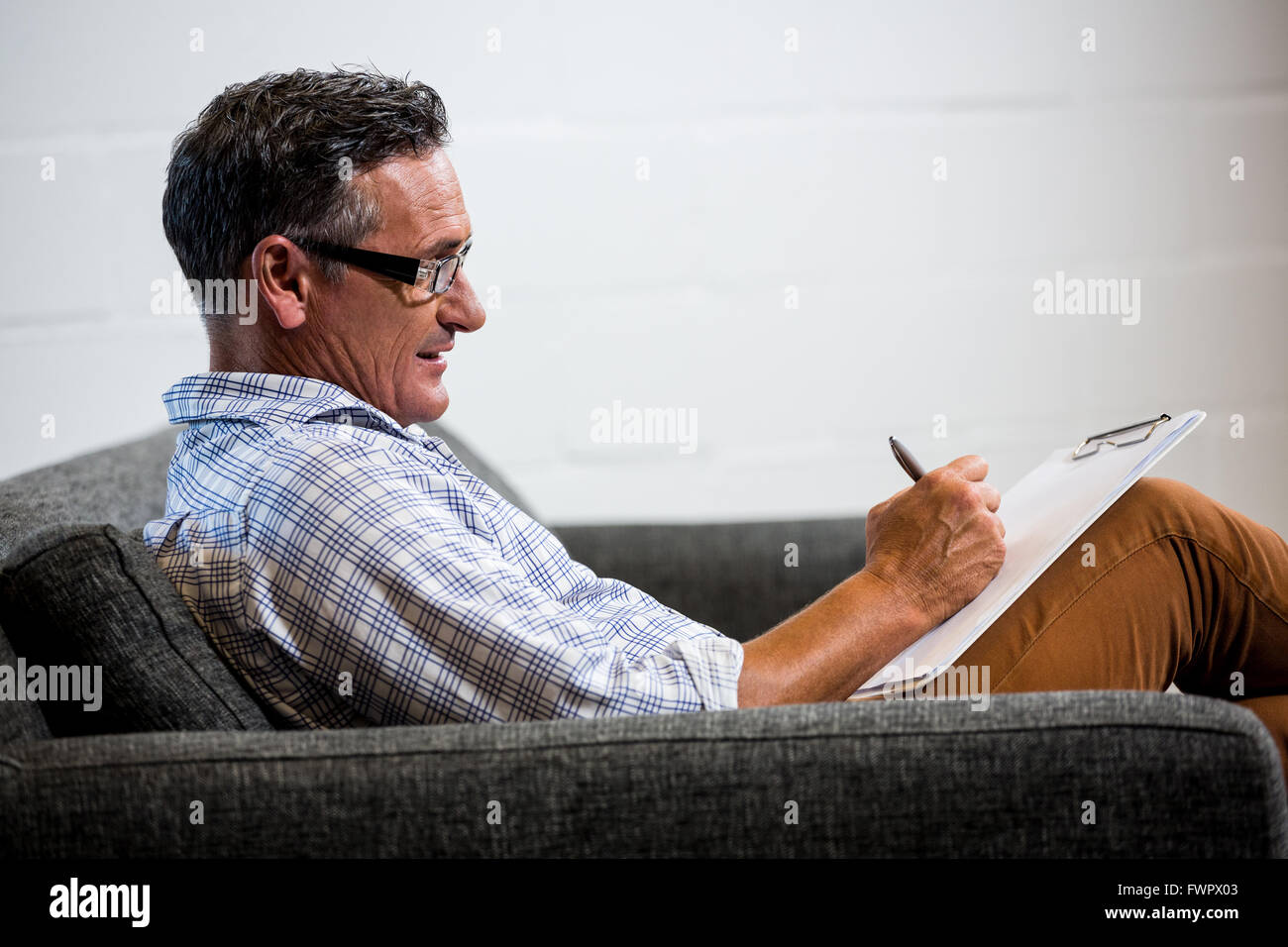 Man writing note on clipboard Stock Photo - Alamy