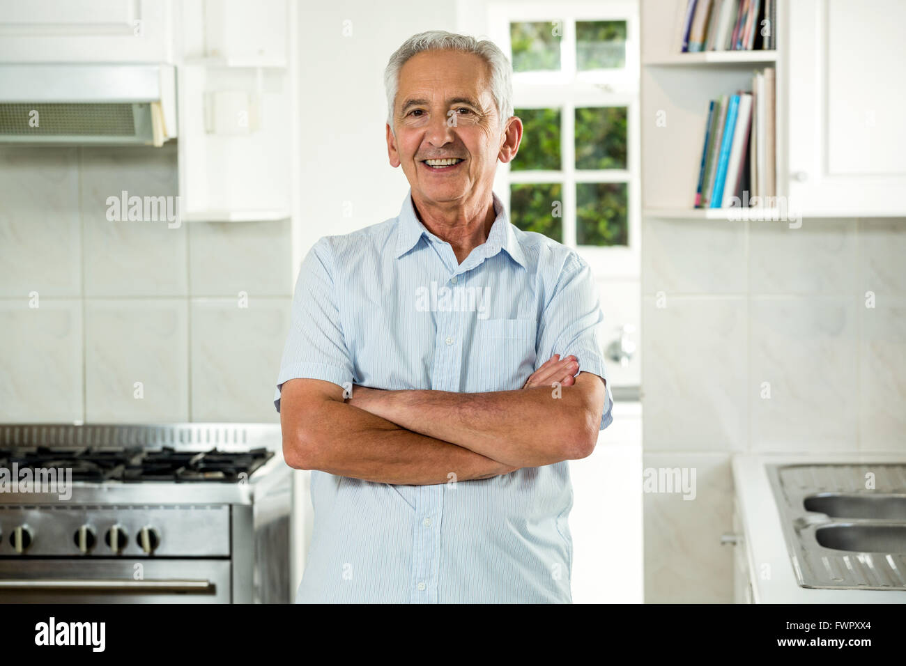 Smiling senior man with arms crossed Stock Photo - Alamy