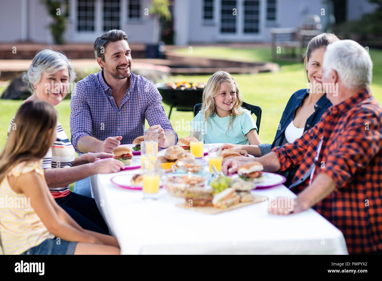 Happy family having lunch in the garden Stock Photo - Alamy