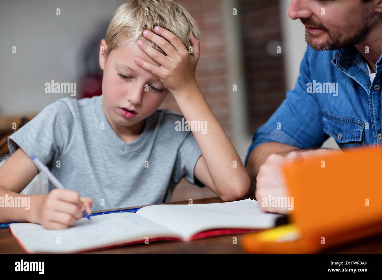 Father helping son with his homework in kitchen Stock Photo - Alamy