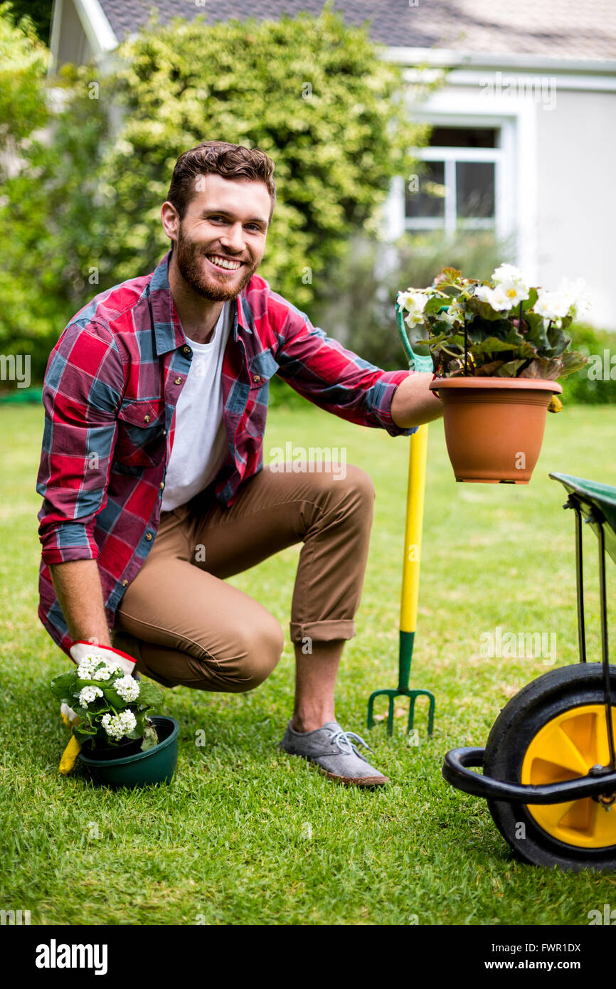 Happy gardener holding potted plants in yard Stock Photo - Alamy