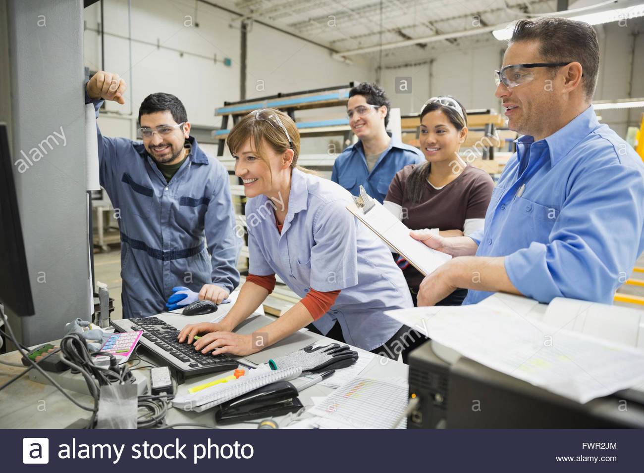 Workers using computer in manufacturing plant Stock Photo - Alamy