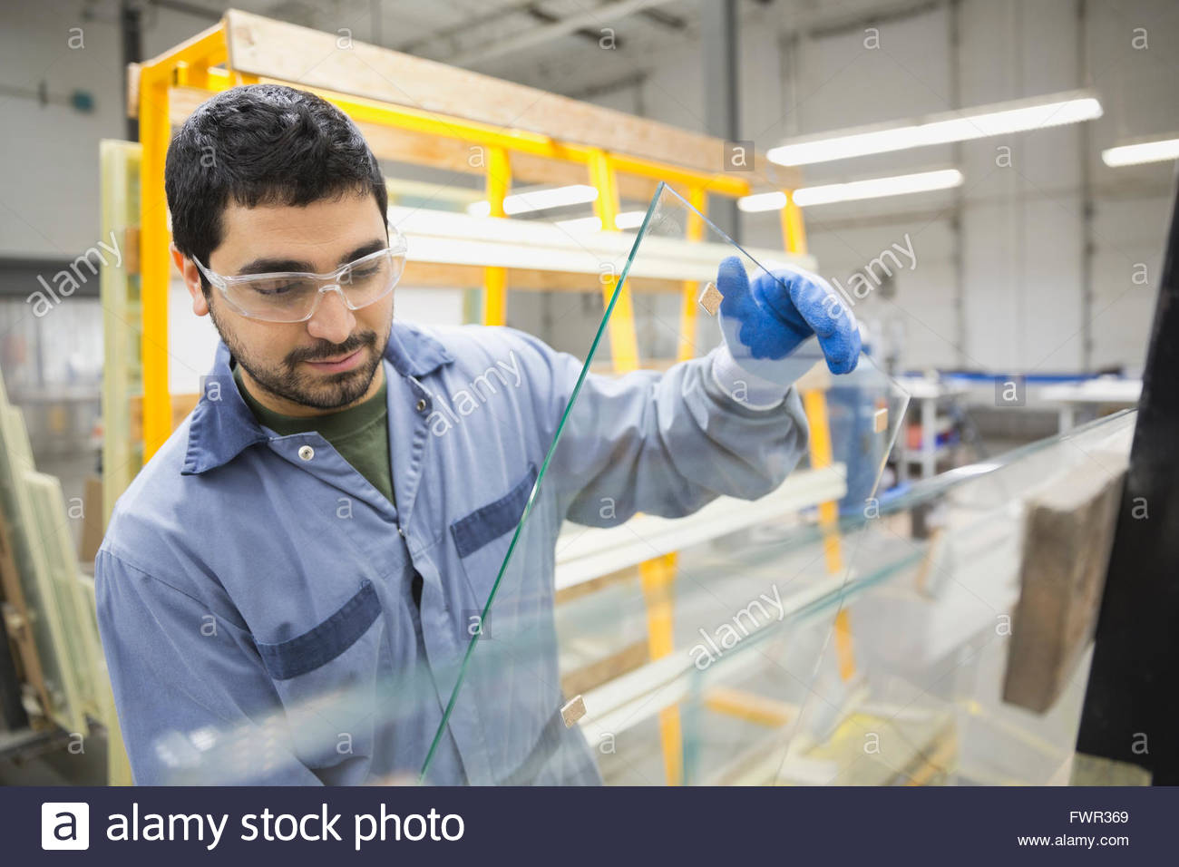 Worker handling glass sheet in warehouse Stock Photo Alamy