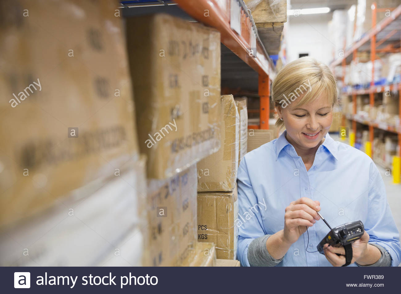 Worker using handheld warehouse device Stock Photo Alamy