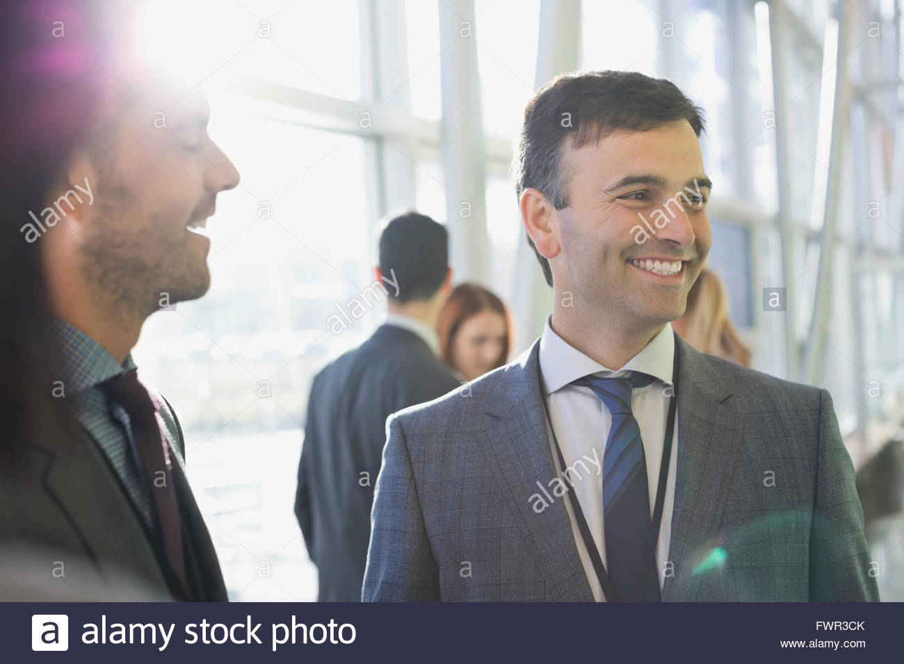 Businessmen smiling in lobby Stock Photo - Alamy