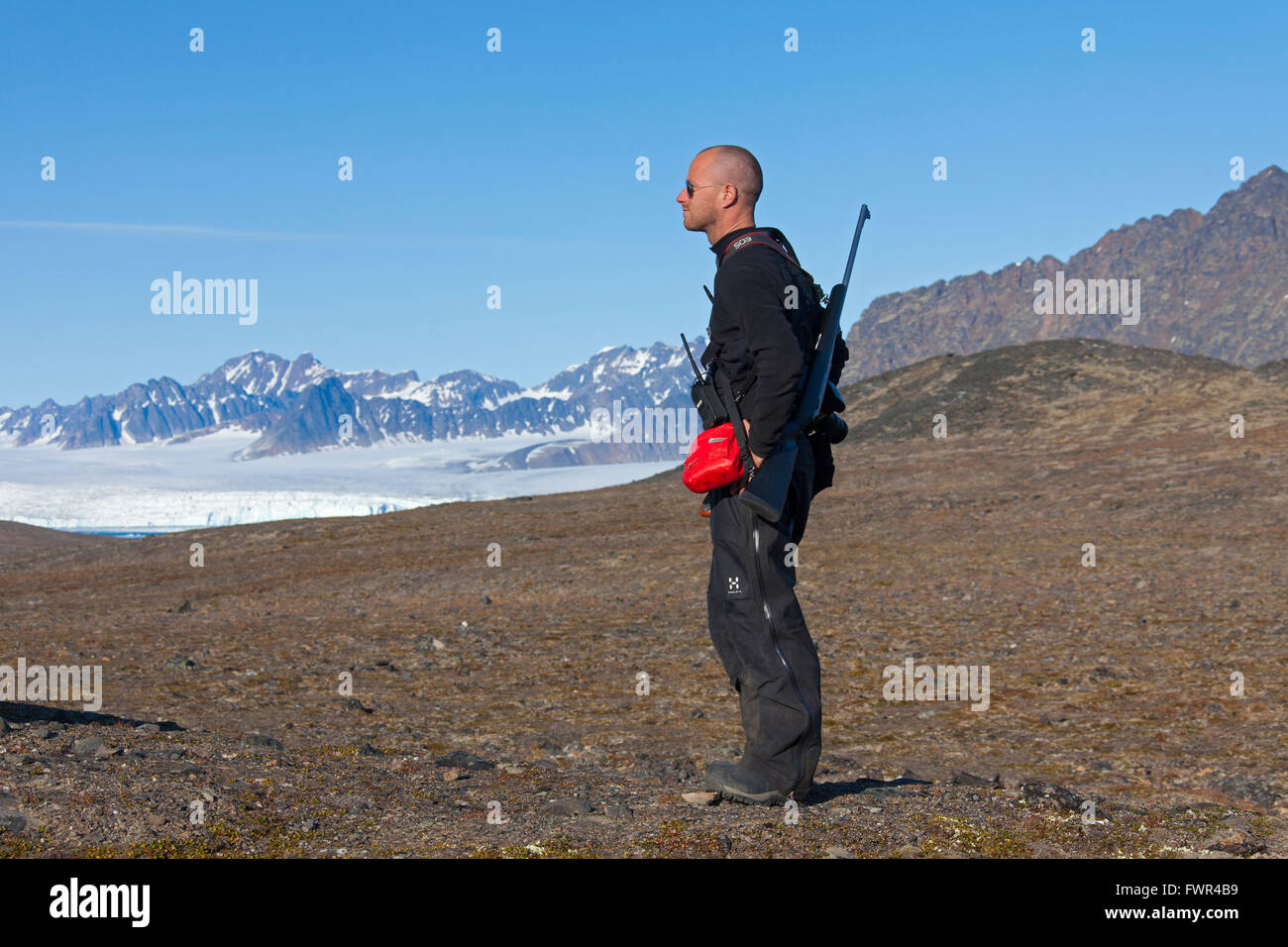 Polar bear guard armed with rifle on the lookout for polar bears, Svalbard, Norway Stock Photo