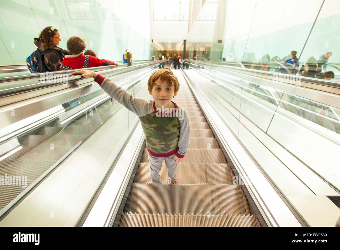 Boy on the escalator at Terminal Two, Heathrow Airport, London, England
