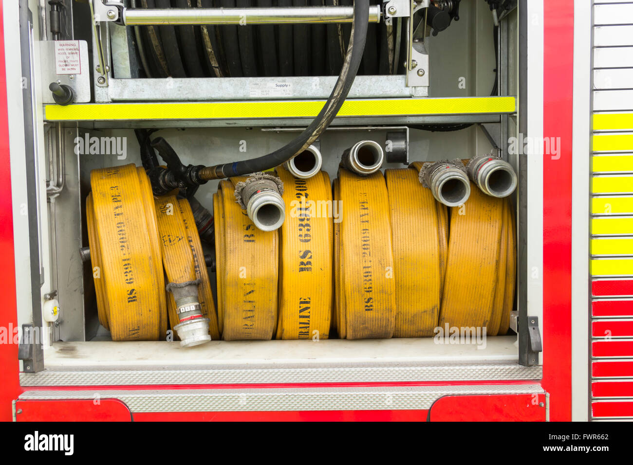 Compartment of rolled fire hoses on a fire engine. The vehicle is a DAF LF series truck with coachwork by Browns of Lisburn. Stock Photo