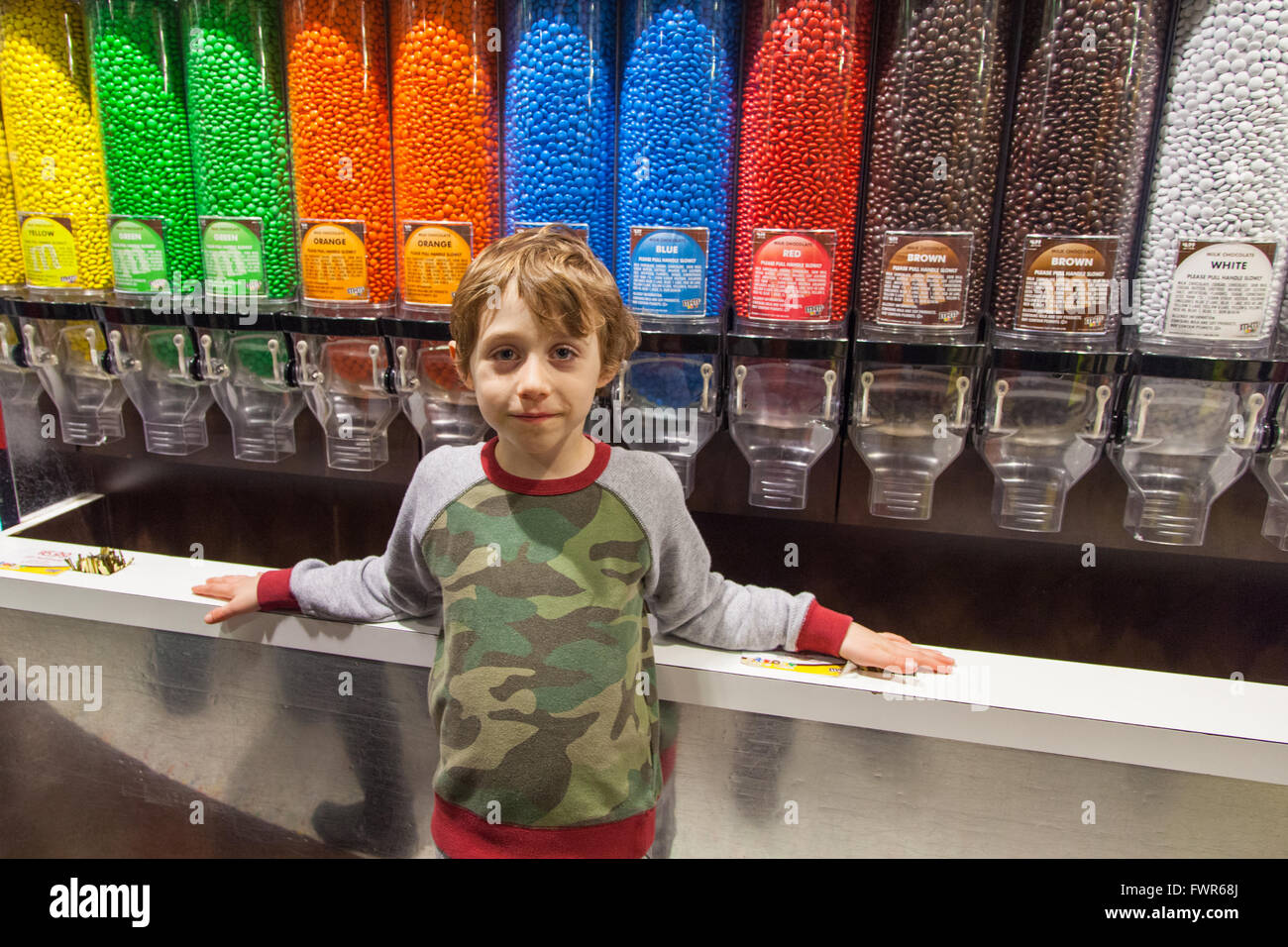 Six year old boy in front of the chocolate dispenser's at the M&M store,Times Square, Manhattan, New York City, America. Stock Photo