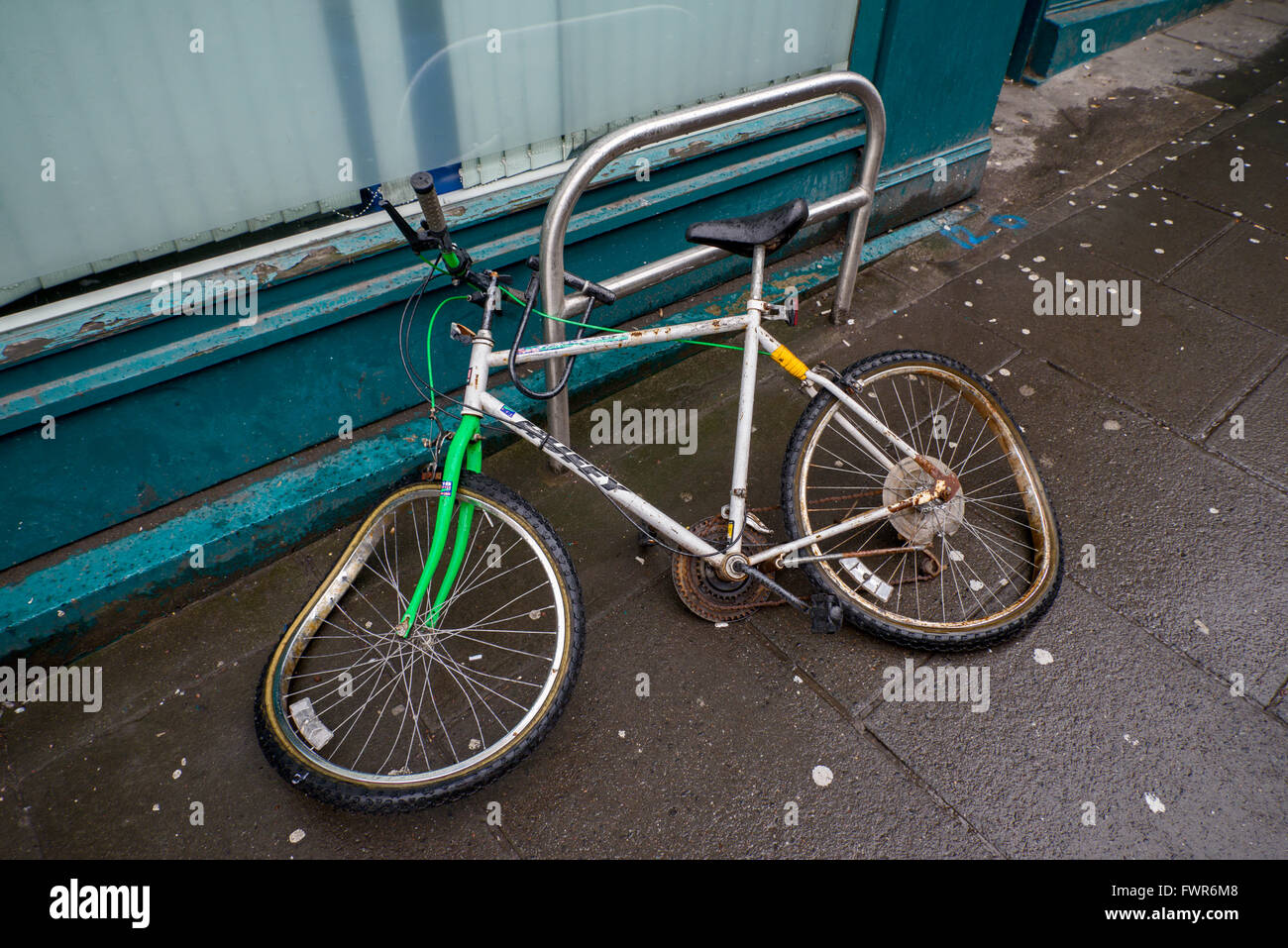 A trashed bicycle still locked to a bike stand in the centre of Edinburgh. Stock Photo