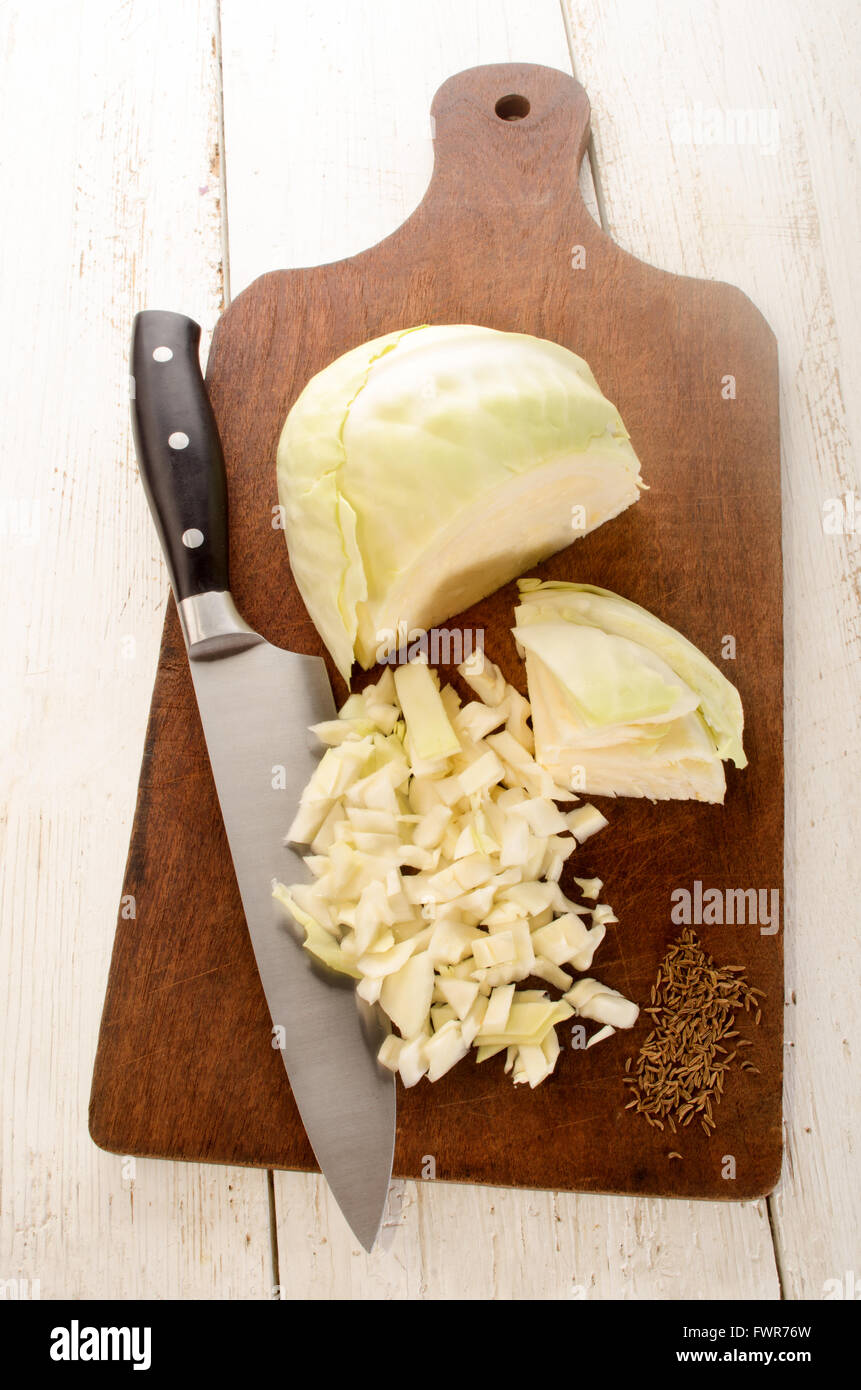 chopped white cabbage and caraway seed on wooden board Stock Photo