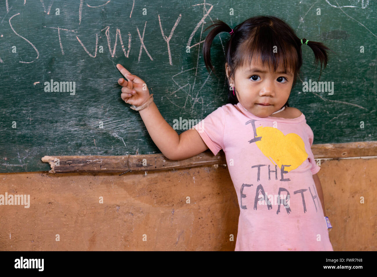 Little girl student pointing to a blackboard, Akha hilltribe, Chiang Rai Province, Northern Thailand, Thailand Stock Photo
