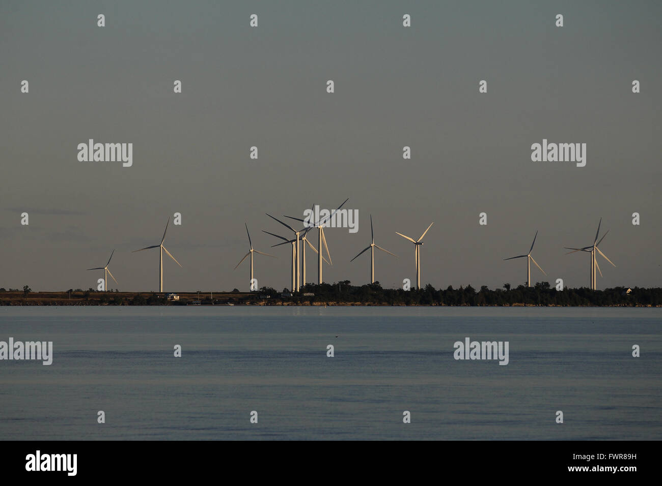 A sailboat makes its way past Wolfe Island's wind turbines on Lake Ontario near Kingston, Ont