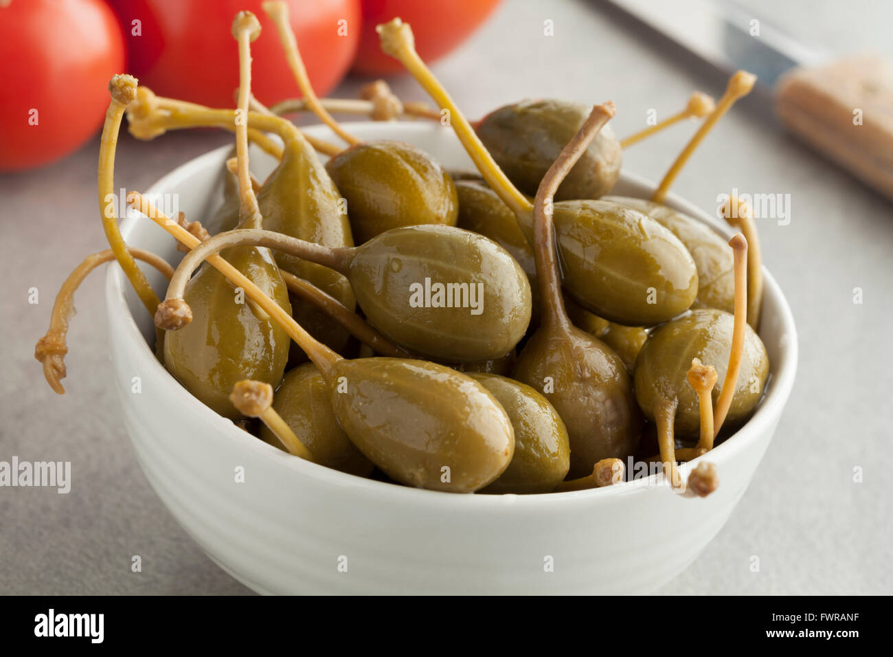 Bowl with pickled caperberries close up Stock Photo