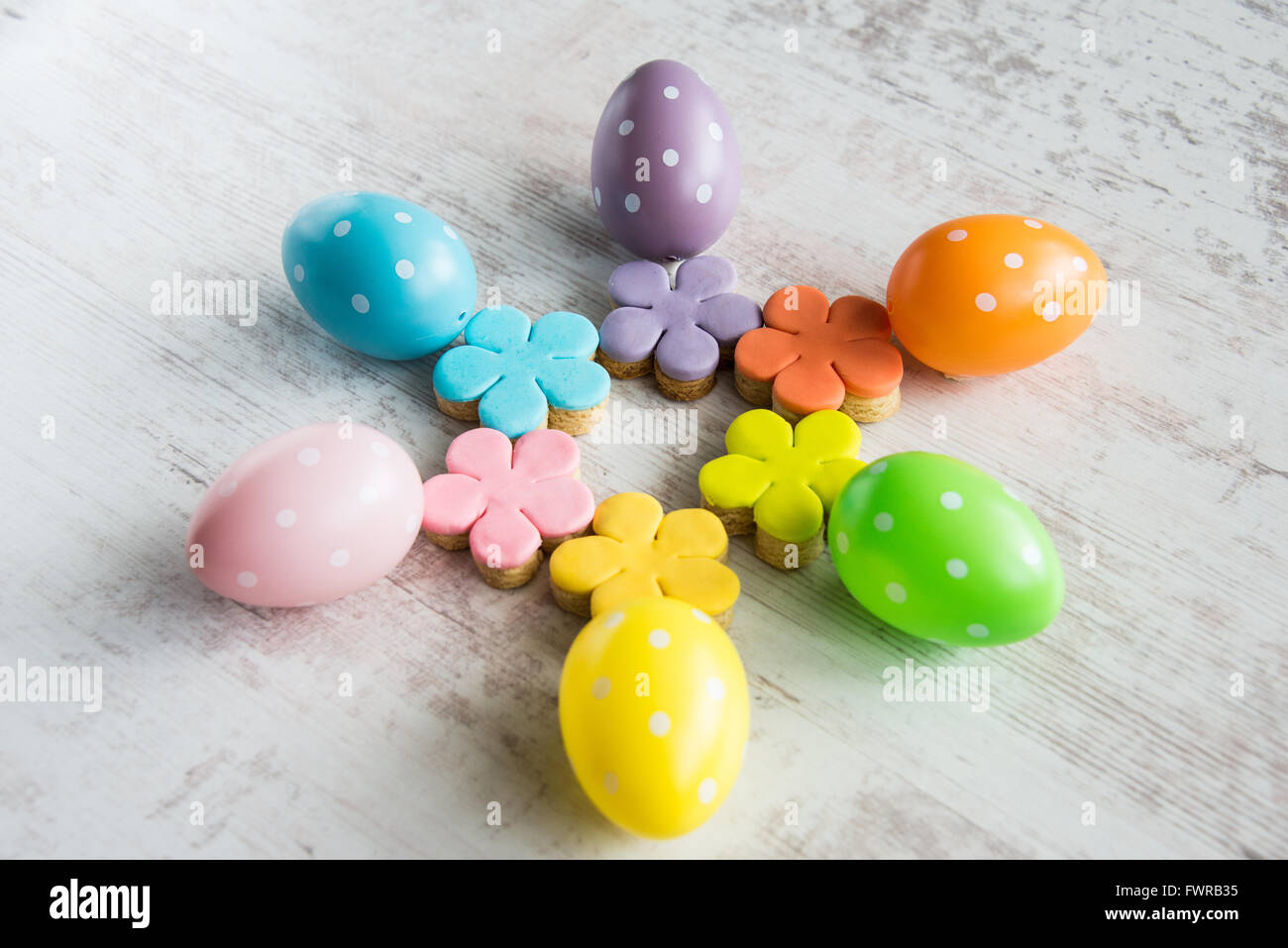 Colorful easter eggs with flower cut fondant covered homemade cookies Stock Photo