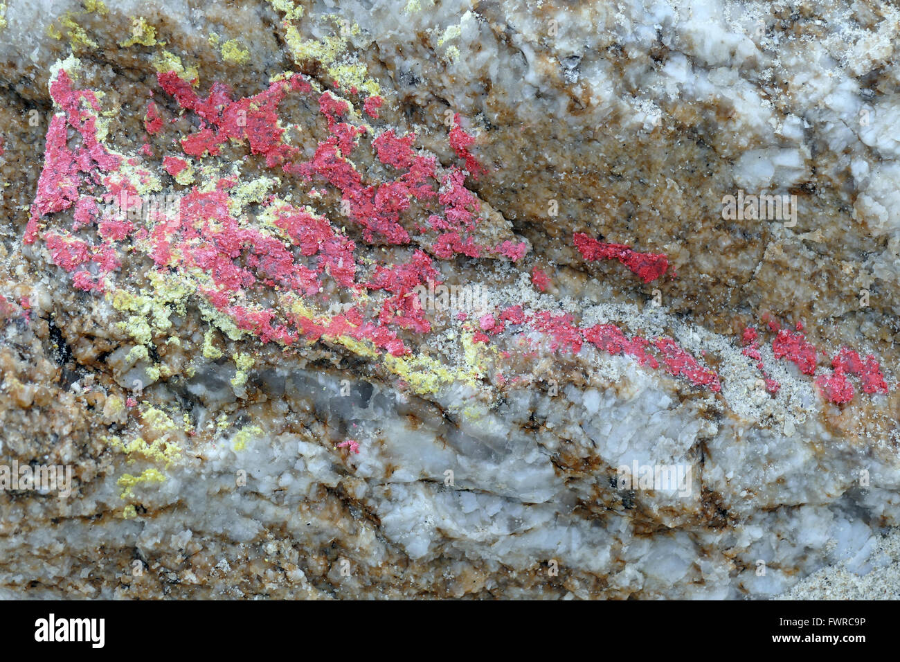 Stone. Structure of granite. Closeup. Red and yellow paint. Stock Photo