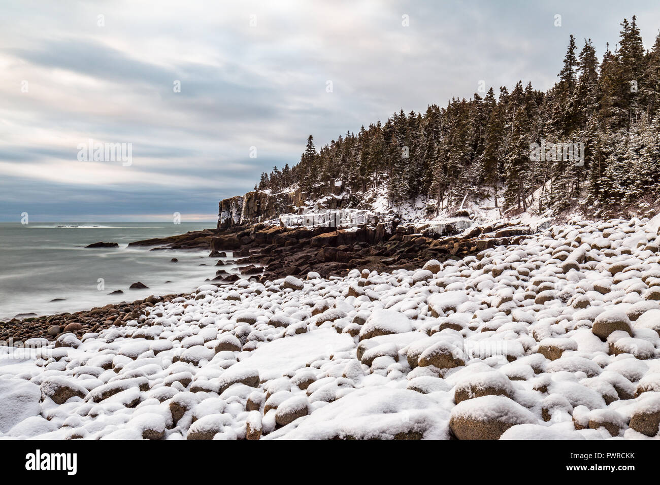 Otter Cliffs seen from a snow covered Boulder Beach in Acadia National Park, Mount Desert Island, Maine. Stock Photo