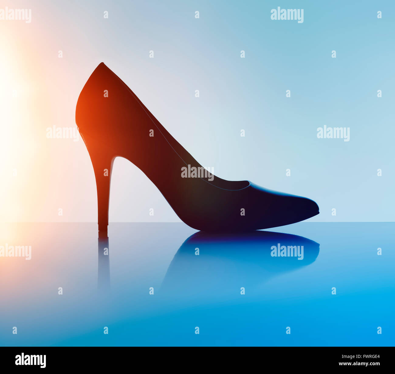 Women's black pump shoe in silhouette and with lens flare. Stock Photo