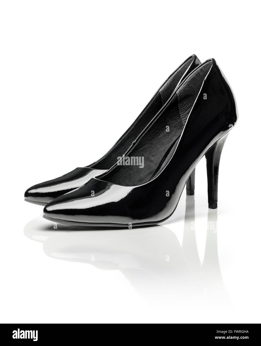 Black shiny patent leather stiletto heel pumps isolated on white with natural reflection. Stock Photo
