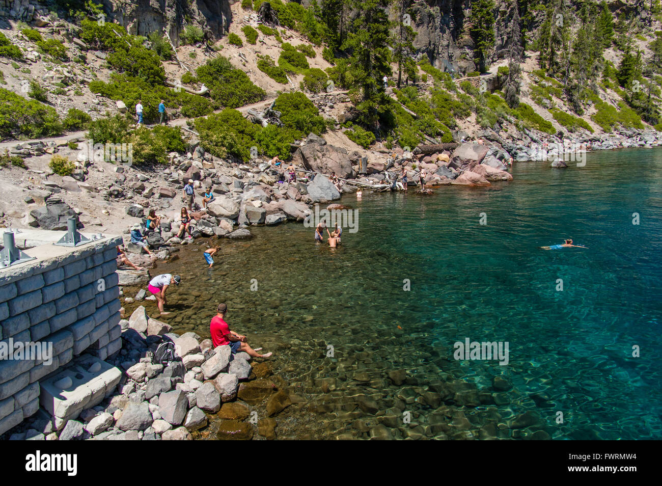 Tourists swimming in the crystal clear water of Crater Lake.  Crater Lake National Park, Oregon Stock Photo