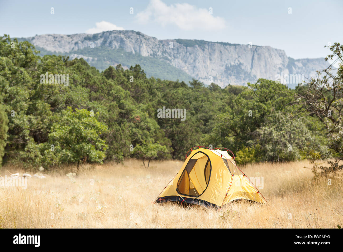 Tent on a sunny meadow against mountains Stock Photo - Alamy