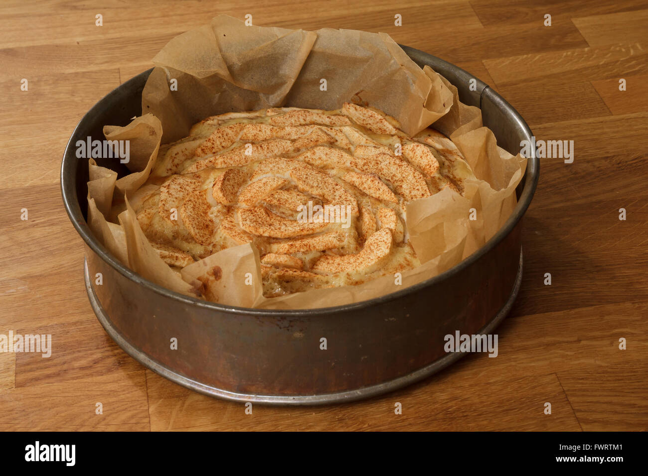 Baked apple pie in a metal springform standing on a wooden table Stock Photo