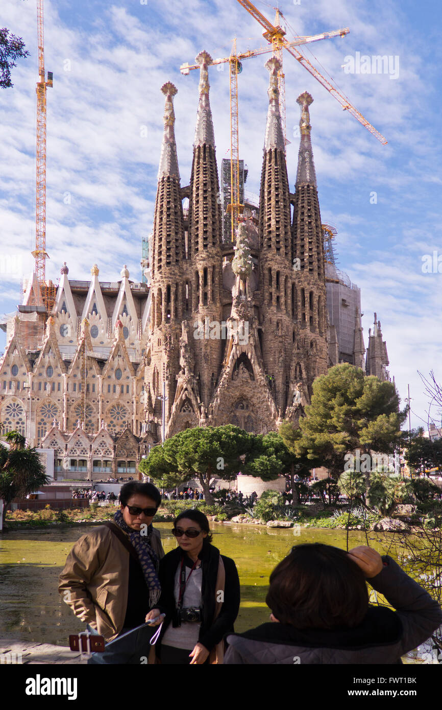 The Sagrada Familia Church with a couple of tourists having their photograph taken,  Barcelona, Spain Stock Photo