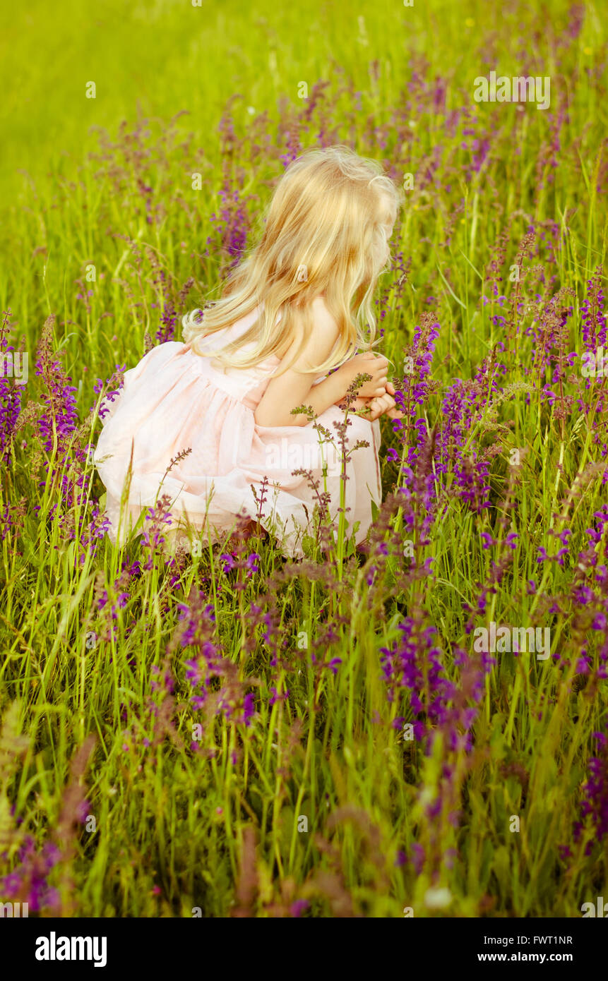 beautiful little girl in pink flowers back view Stock Photo