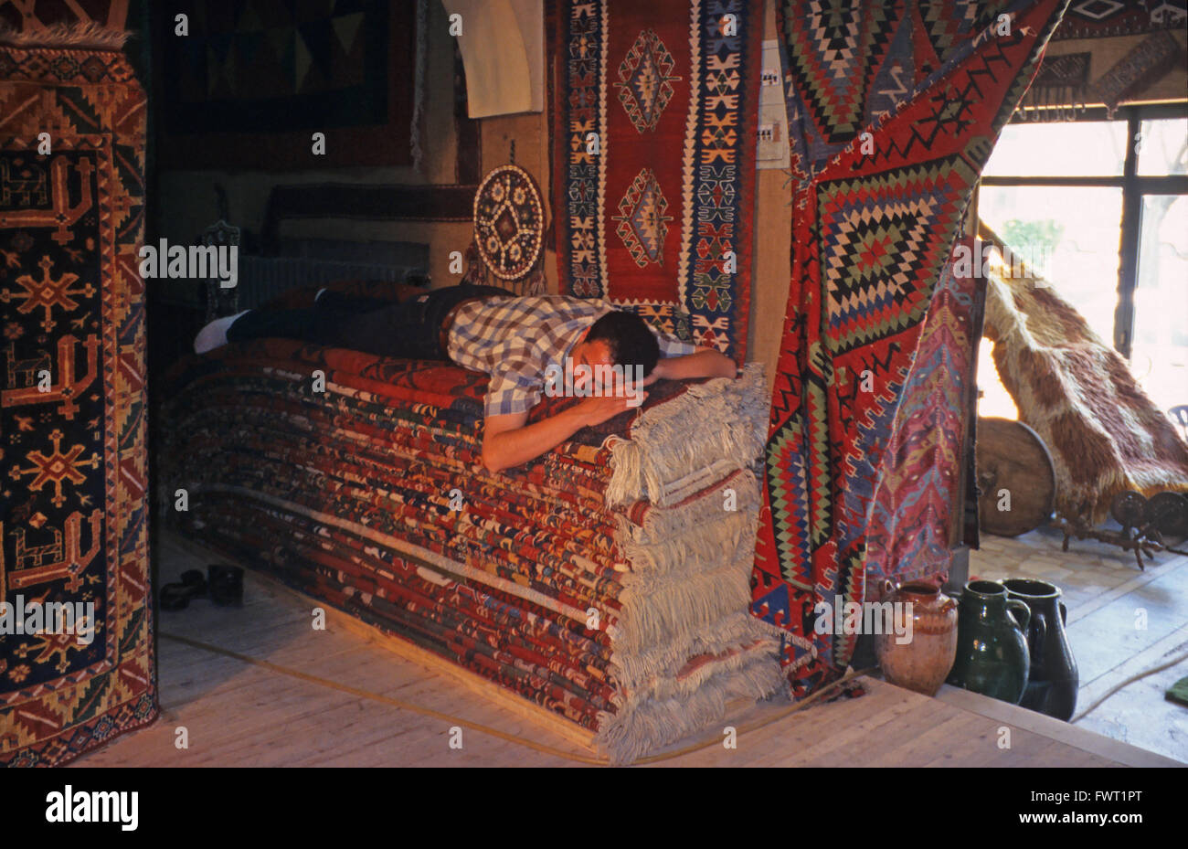 A carpet seller asleep in his shop, Konya, central Anatolia, Turkey Stock Photo