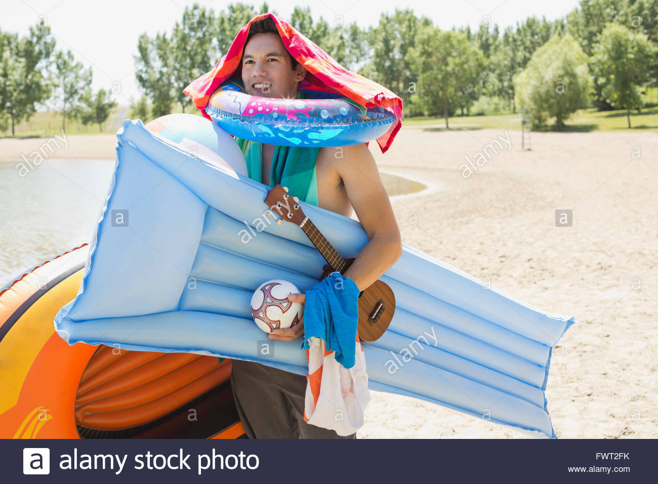 Man carrying inflatable rafts on beach Stock Photo - Alamy