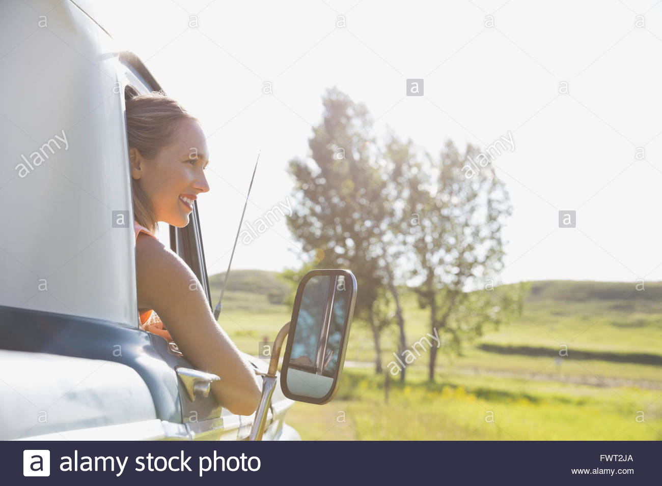 Smiling woman looking out of truck window during road trip Stock Photo ...