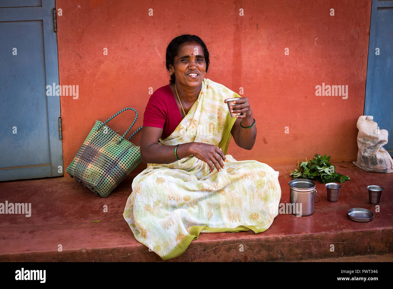 One lady drinking on the route to the Matrimandir, at Auroville, in Viluppuram district in the state of Tamil Nadu Stock Photo